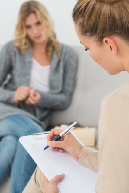 Terapeuta tomando notas durante una sesión